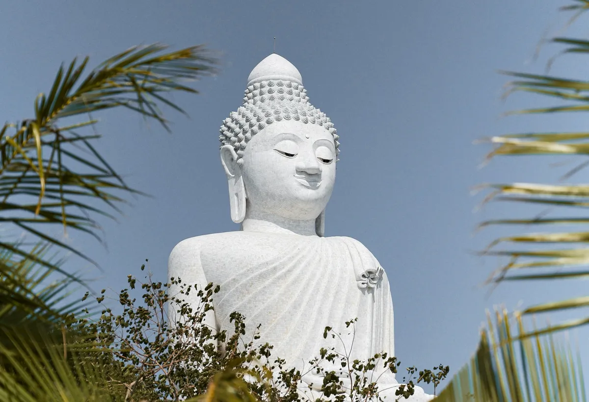 Big Buddha na Phuket widziany przez liście palm