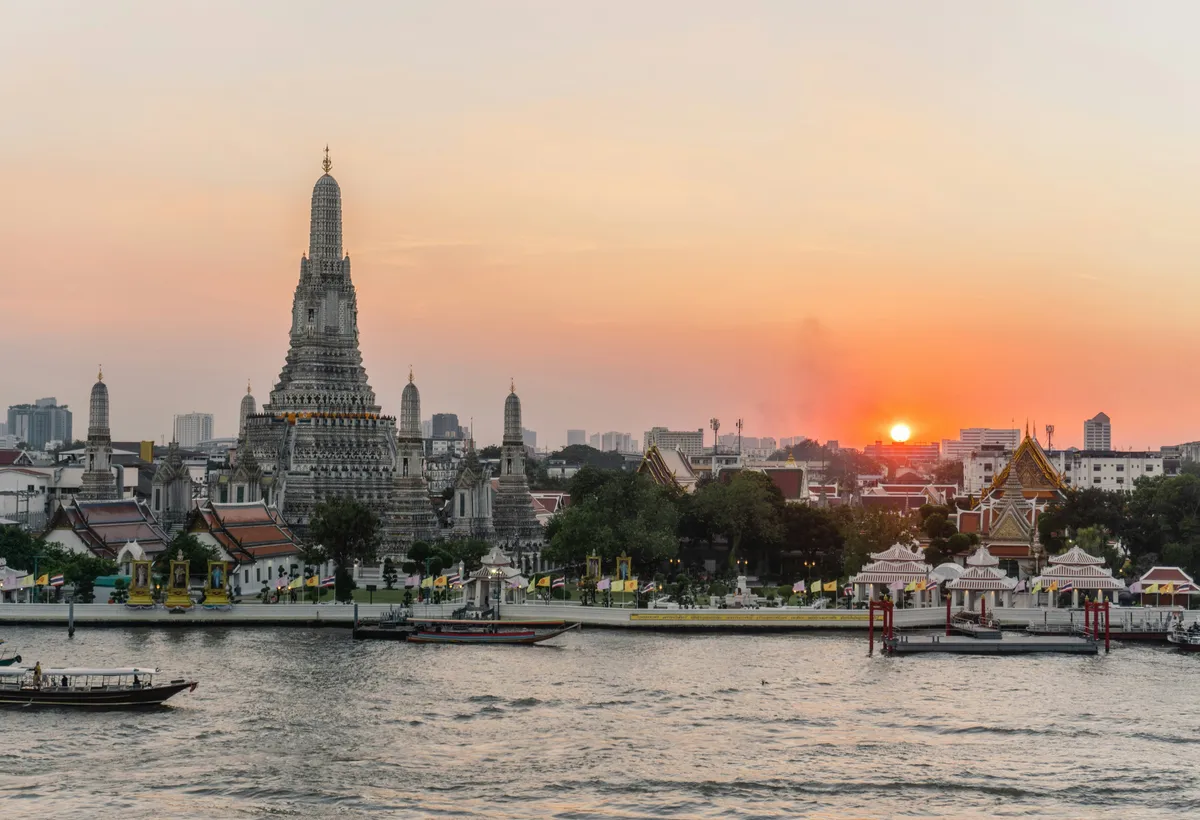 Wat Arun nad rzeką Chao Phraya o zachodzie słońca