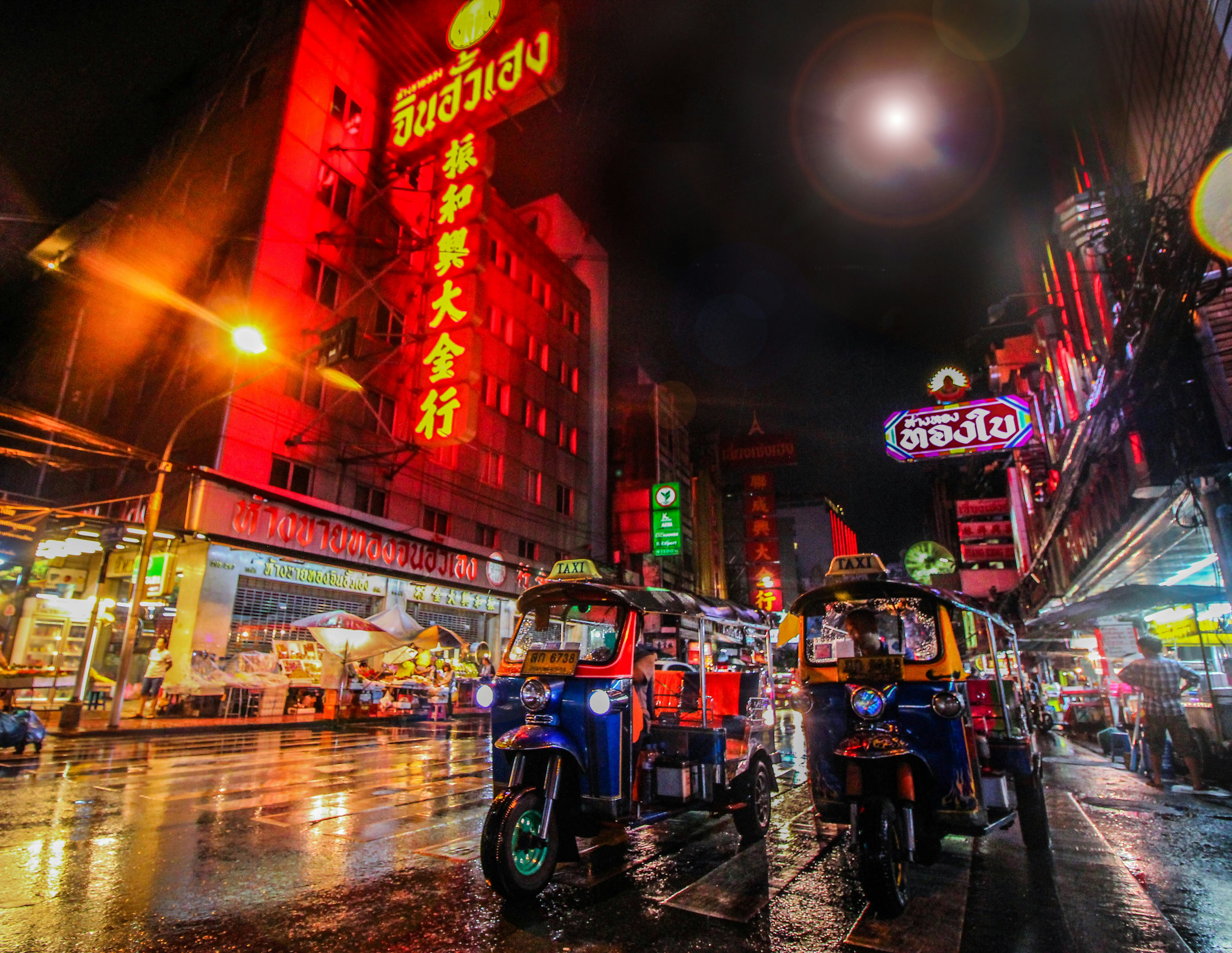 Bangkok nocą z neonami Chinatown i tuk-tukami